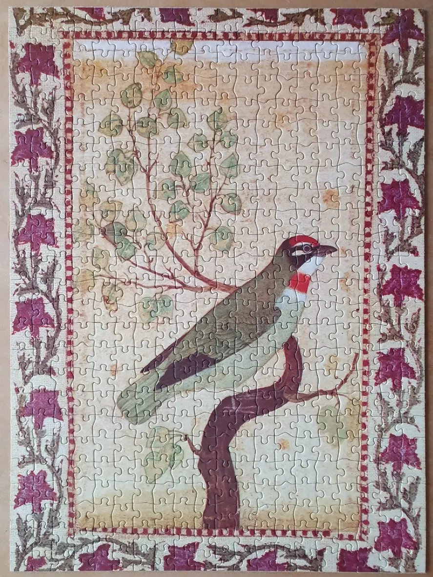An illustration of a bird perched on a branch within an ornate floral border.