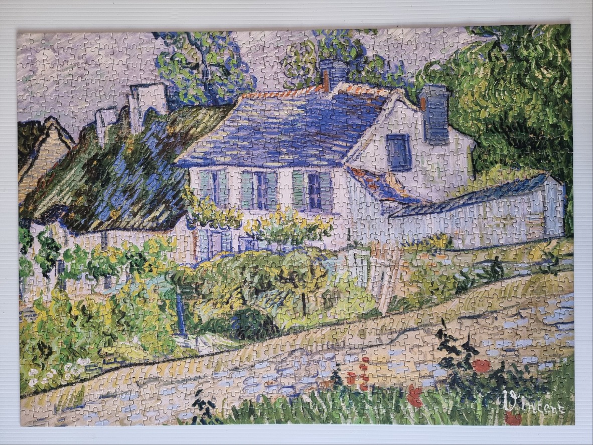 A post-impressionist painting of cottages with thatched roofs behind a stone wall and a garden path.