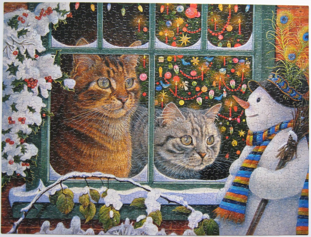 Two cats look through a window at a snowman outside during a festive, snow-covered winter night.