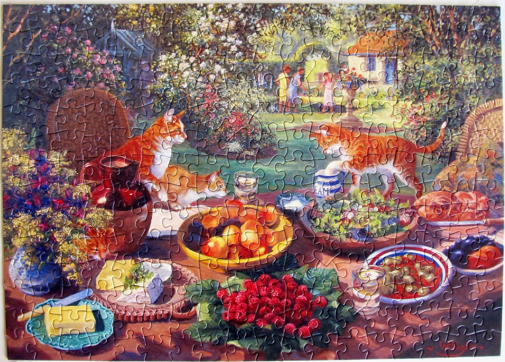 Two ginger cats interacting with a table full of food in a lush garden setting.
