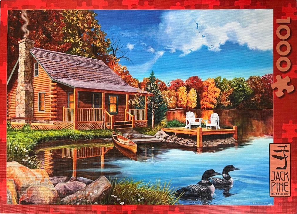 A cozy log cabin beside a lake in autumn with two loons swimming in the foreground.