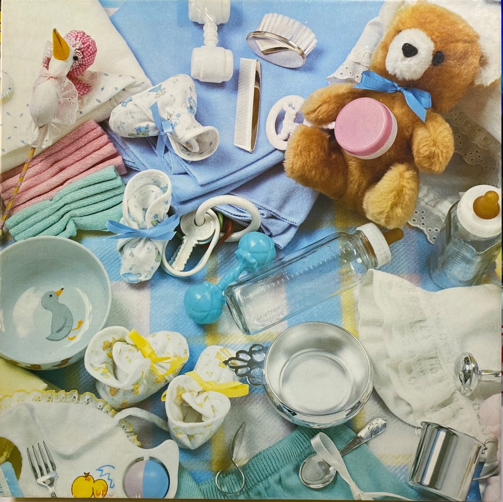 A top-down collection of baby accessories and toys on a blue plaid blanket.