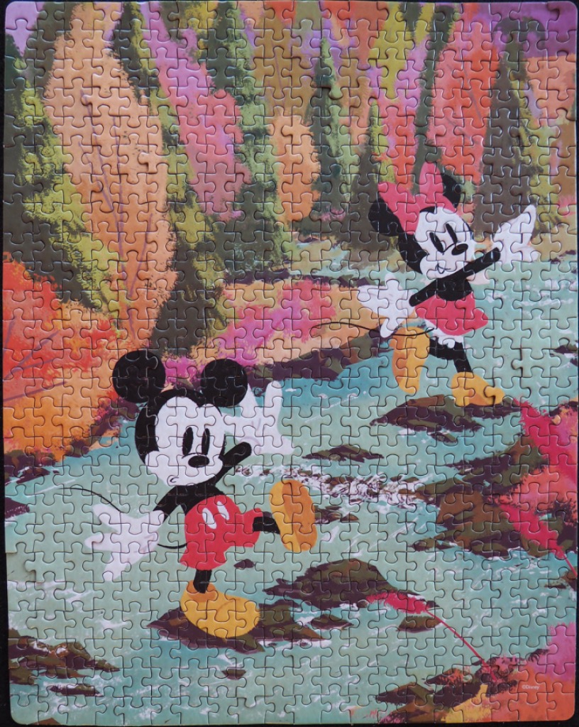 Mickey and Minnie Mouse skipping across rocks in a colorful, impressionistic forest stream.