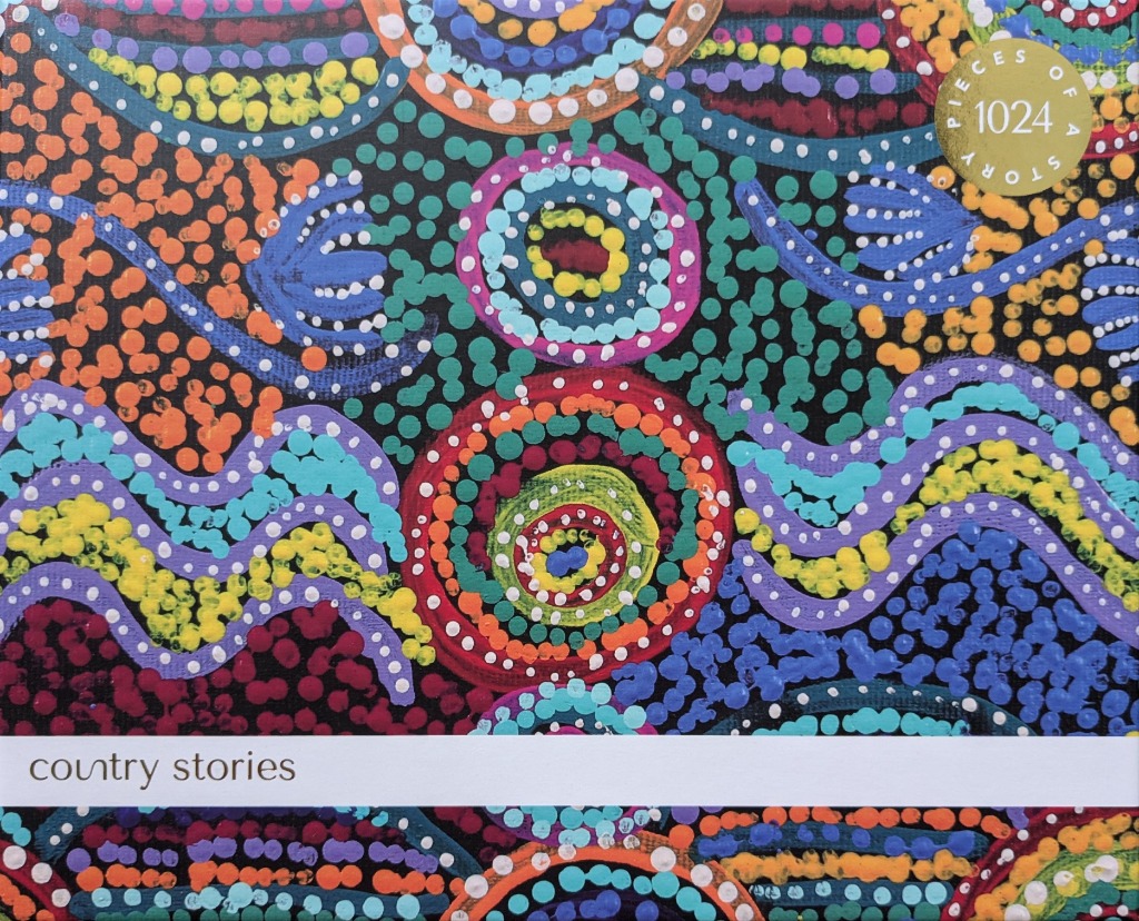 Vibrant abstract dot painting featuring concentric circles and flowing wave patterns in a rainbow of bright colors.