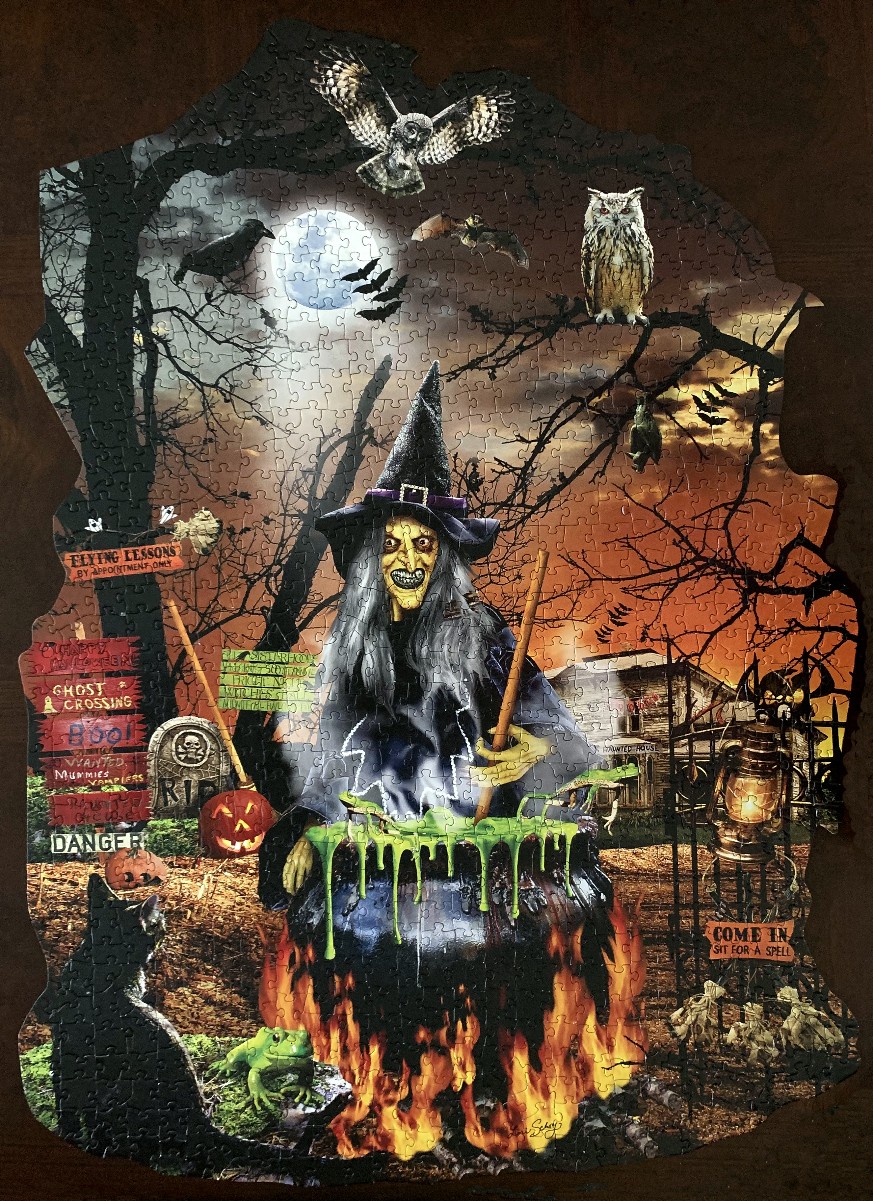 A Halloween illustration featuring a witch stirring a cauldron in a spooky forest at night.