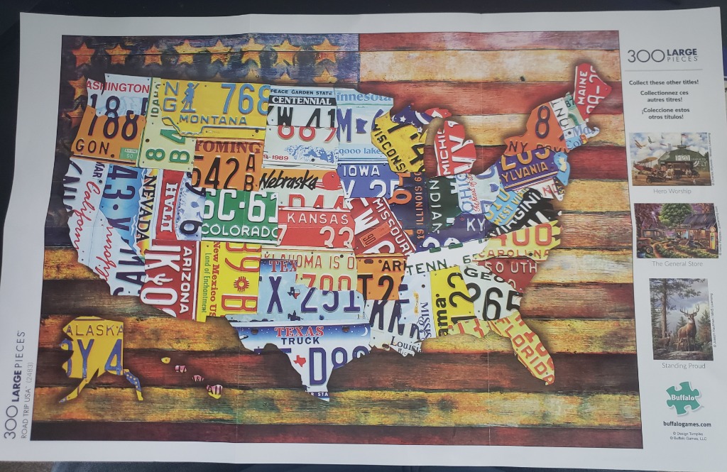 A map of the United States constructed from vintage license plates against a backdrop of the American flag on wood.