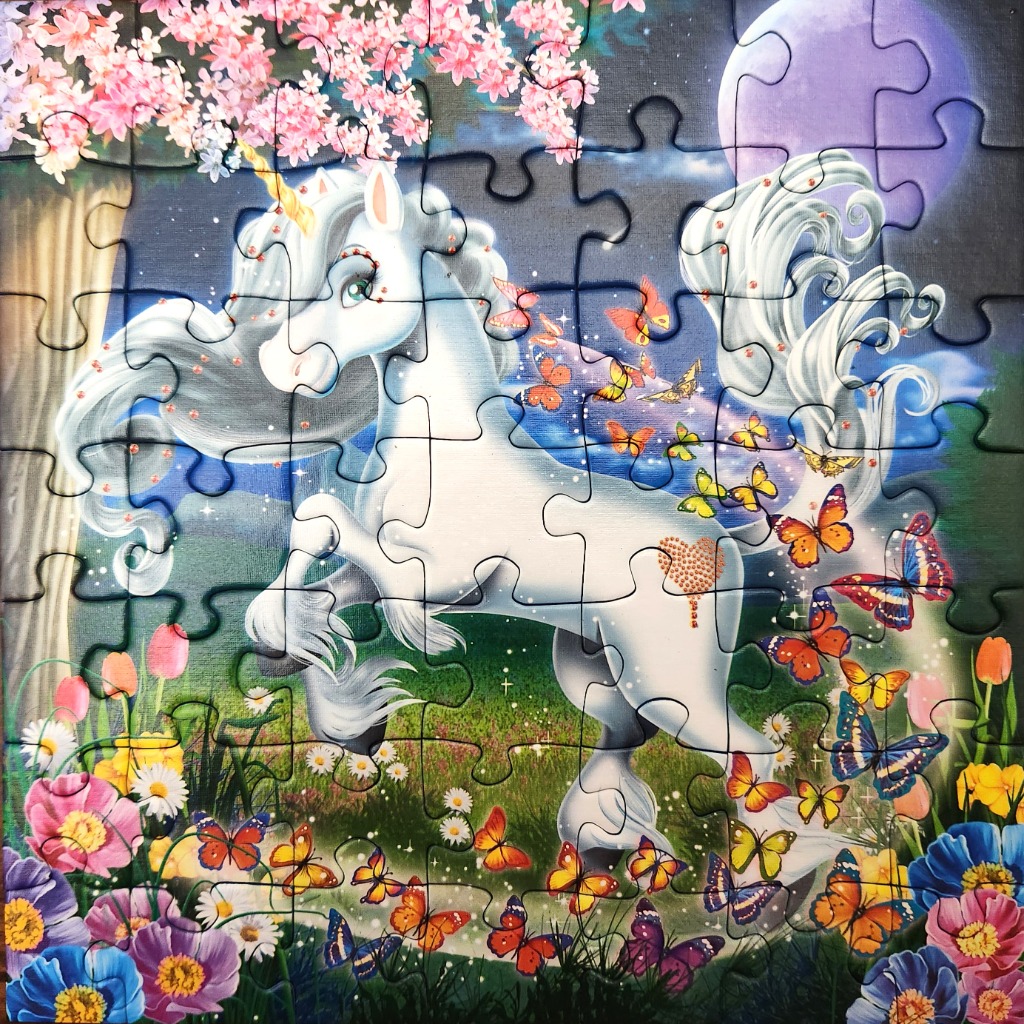 An illustration of a white unicorn standing in a moonlit field surrounded by butterflies and flowers.