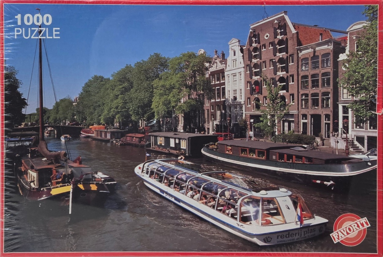 A sunny canal scene in Amsterdam with a glass-topped tour boat and various houseboats moored along the buildings.