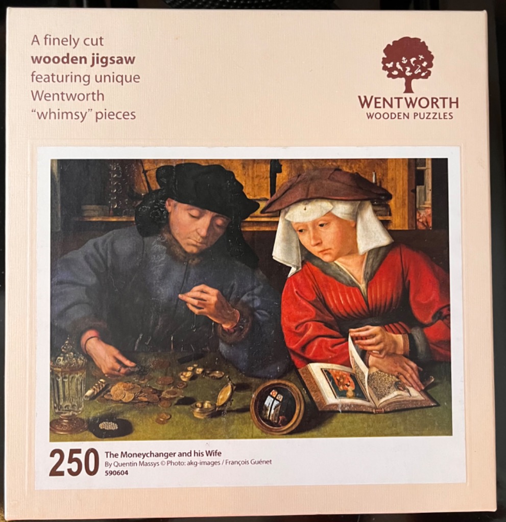 Renaissance painting of a moneychanger and his wife sitting at a desk examining coins and a book.