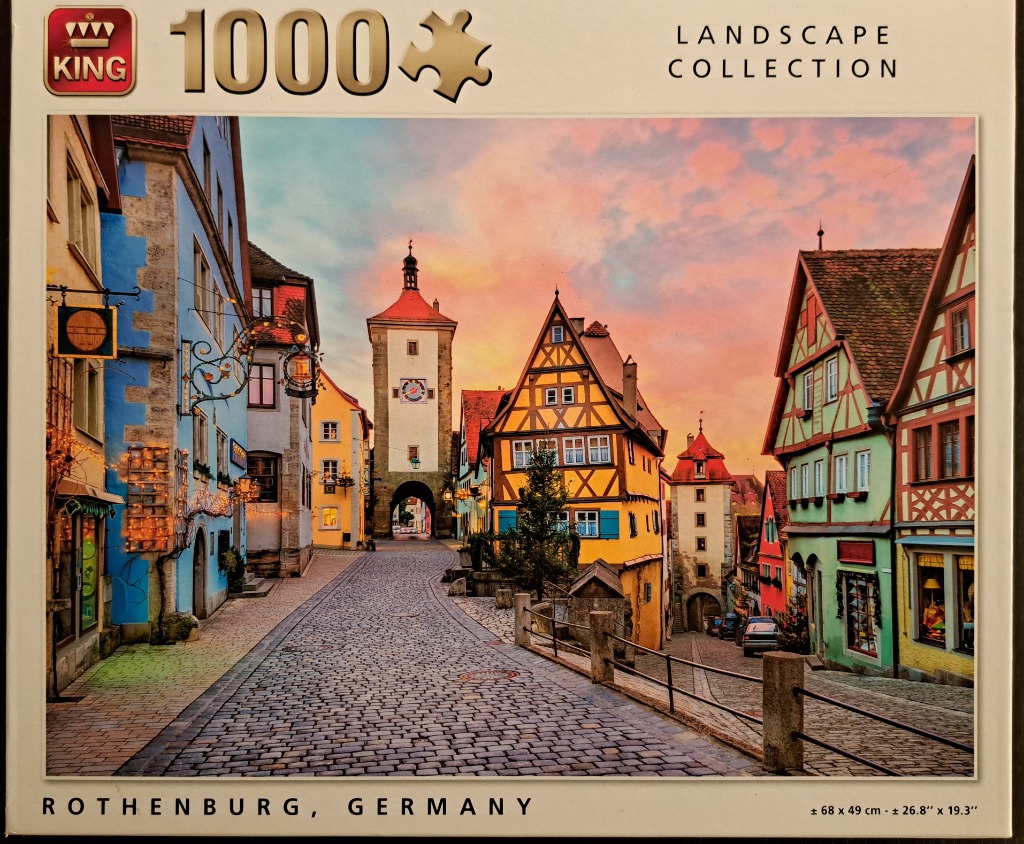 A charming, cobblestone street in Rothenburg, Germany, at sunset with vibrant, colorful timber-framed buildings.