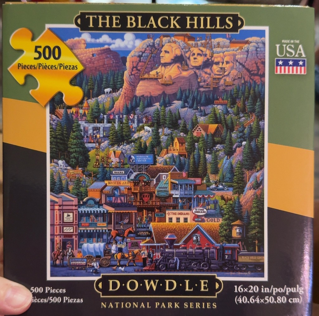 Illustration of Mount Rushmore towering over a busy, stylized frontier-style town in the Black Hills.