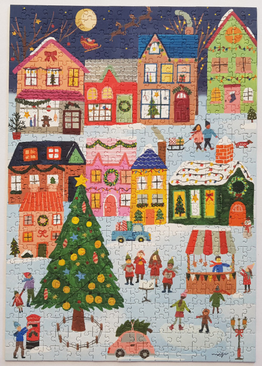 A whimsical illustration of a snowy town square decorated for Christmas at night with a large decorated tree.