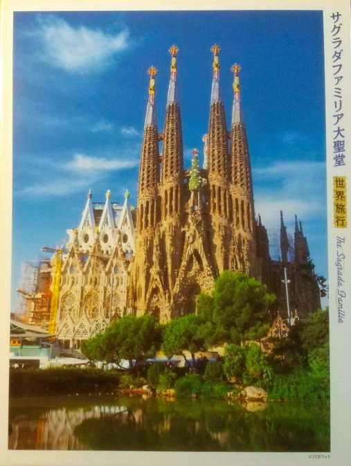 The Sagrada Familia basilica bathed in warm sunlight under a bright blue sky.