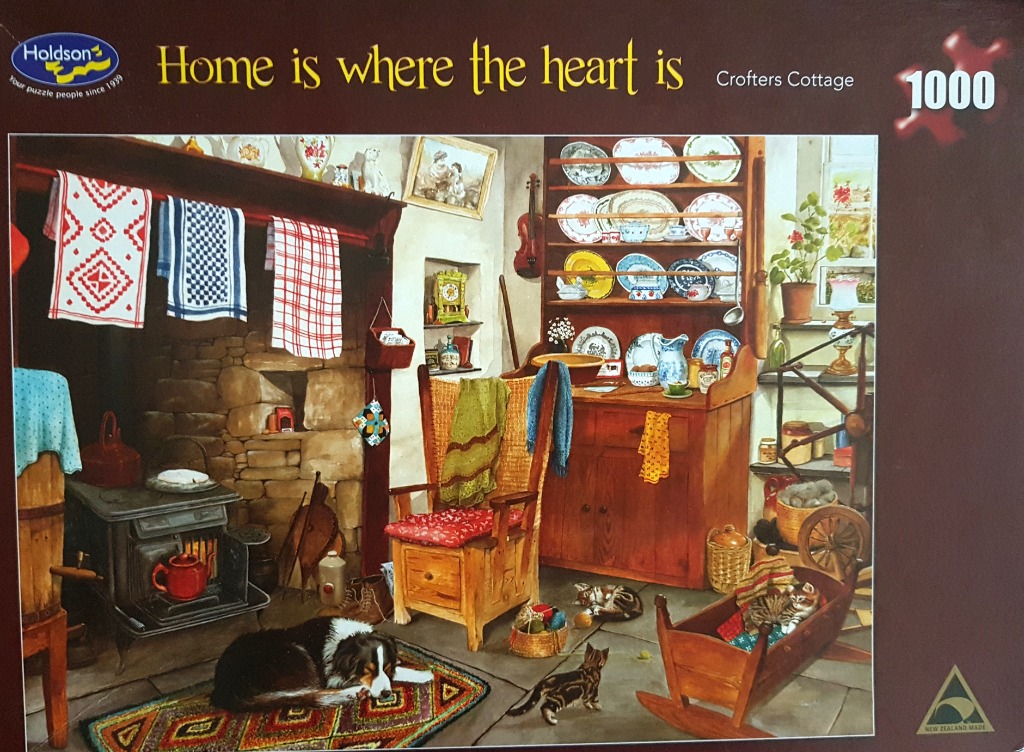 A cozy, rustic cottage interior featuring a stone fireplace, a wooden dresser, a rocking chair, and sleeping pets.