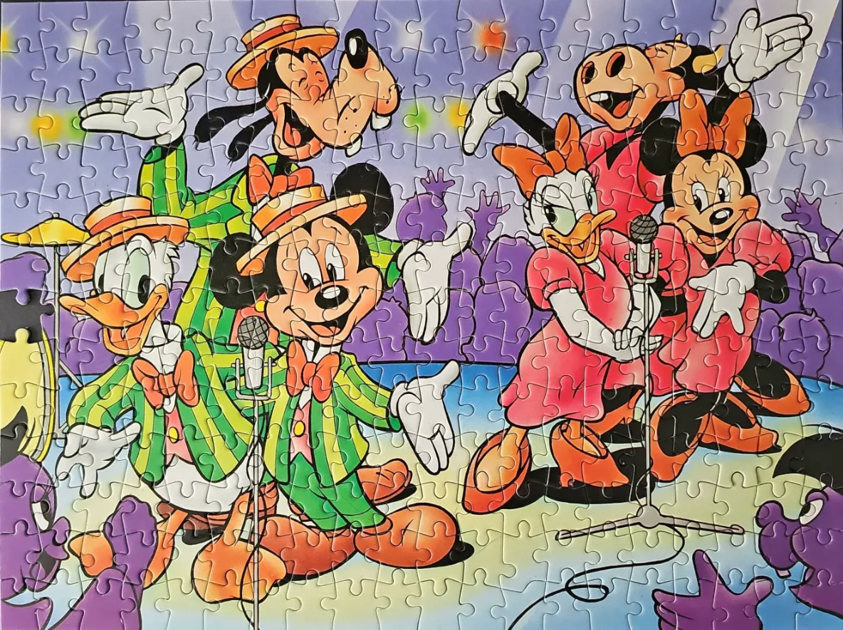 Classic Disney characters performing on a colorful stage as a band.