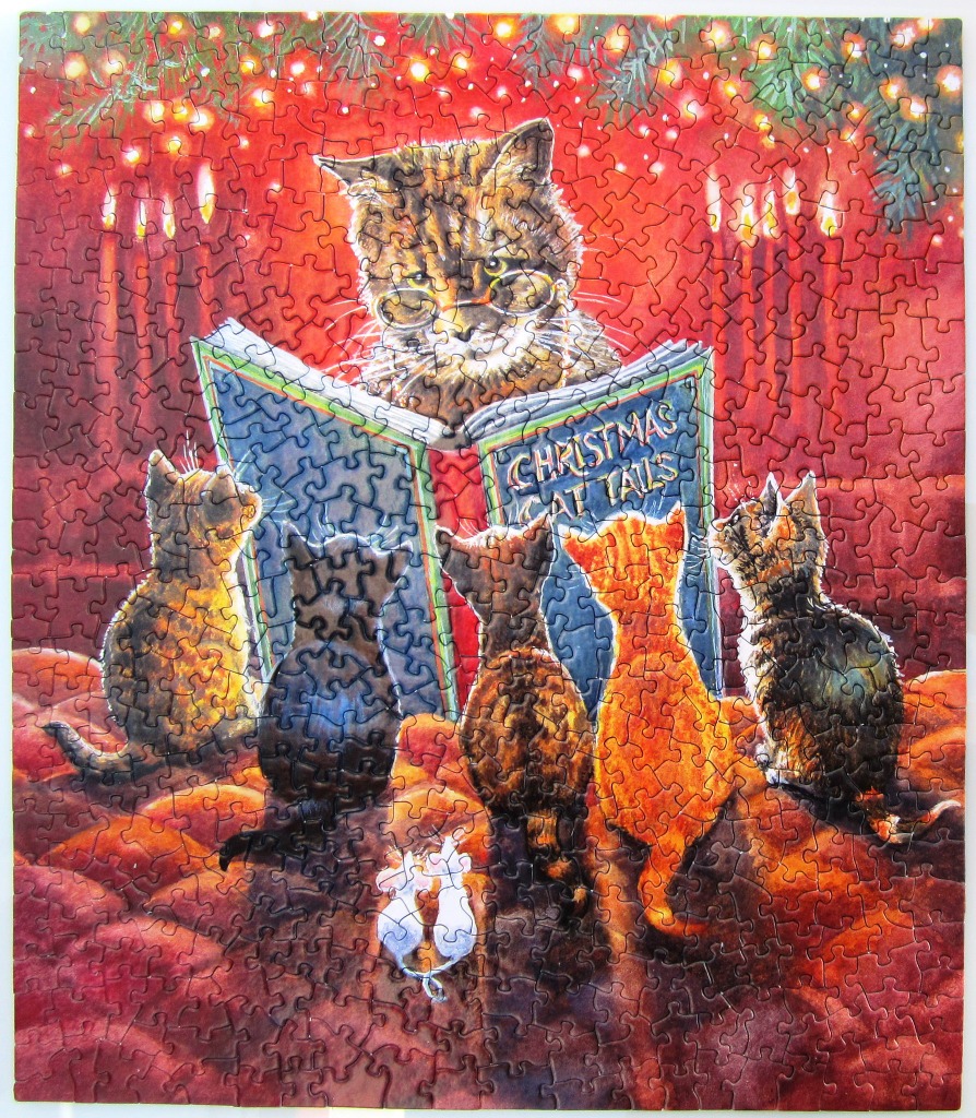 A tabby cat reading a book titled Christmas Cat Tails to a group of kittens.