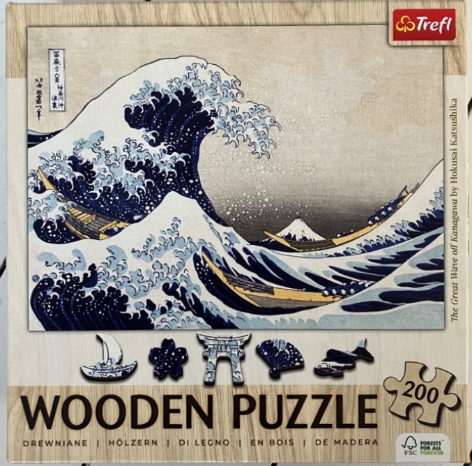 A reproduction of Hokusai's The Great Wave off Kanagawa featuring a towering dark blue wave and Mount Fuji.