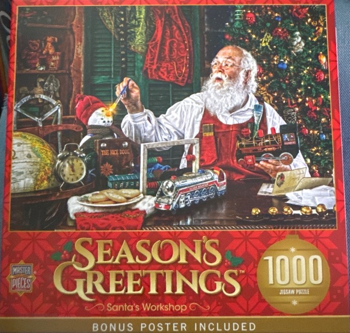 Santa Claus painting a snowman in his cozy, toy-filled workshop with a decorated Christmas tree in the background.