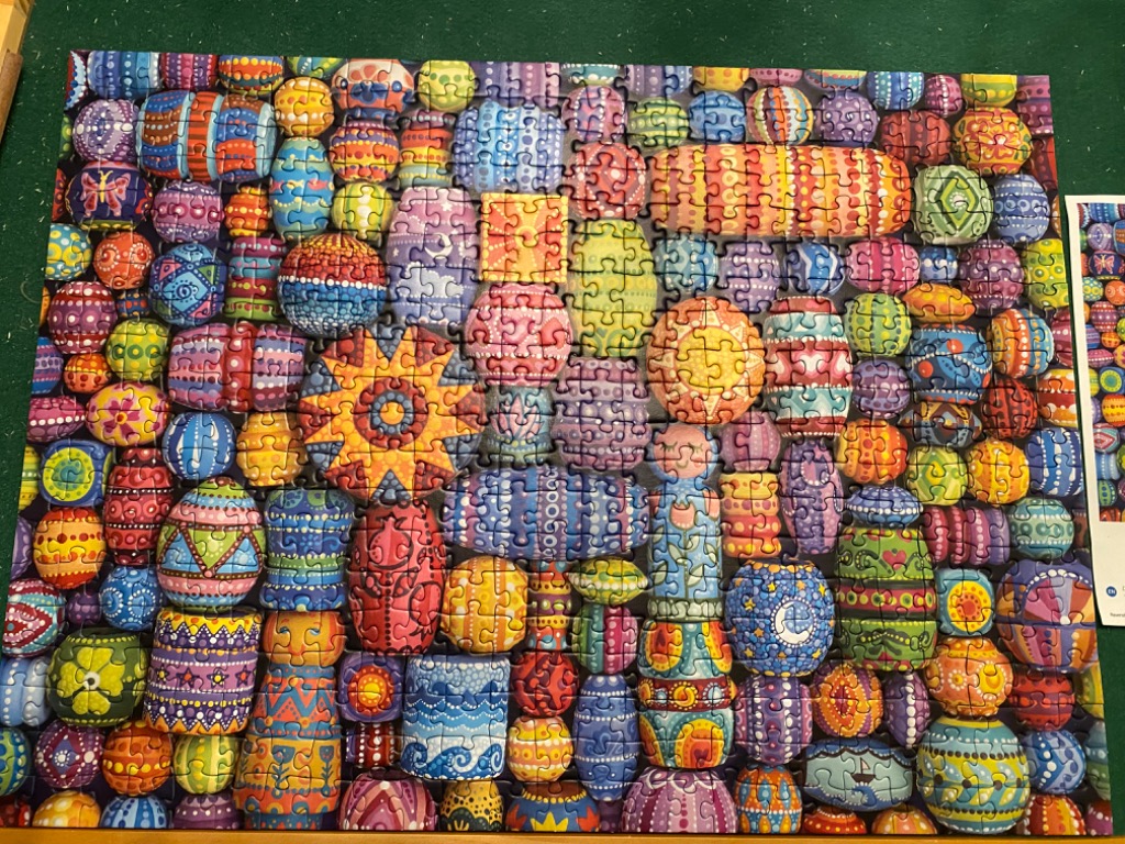 A collection of colorful, patterned, and stylized egg-shaped stones packed together in a mosaic-like display.