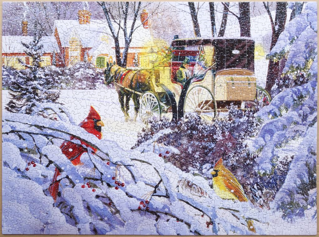 A horse-drawn carriage in a snowy village scene with two cardinals in the foreground.