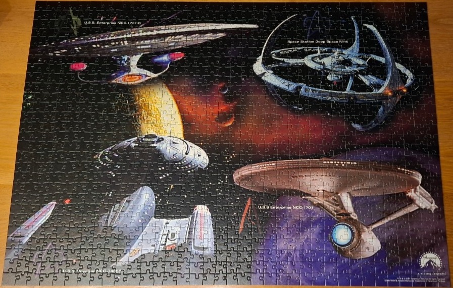 Illustration of iconic Star Trek starships and Deep Space Nine floating in a dark nebula.