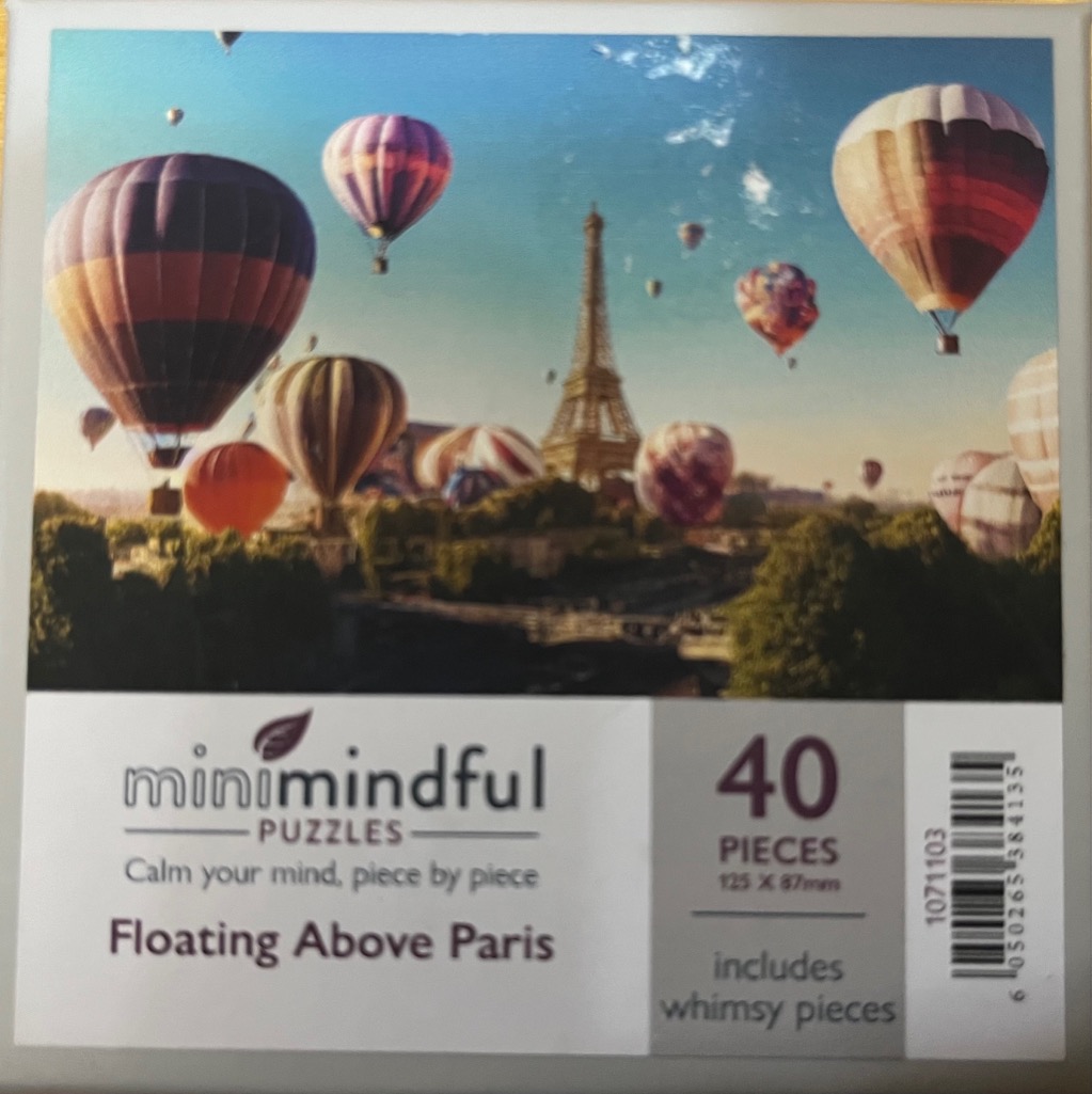 Hot air balloons drifting over the Eiffel Tower in Paris at sunset.