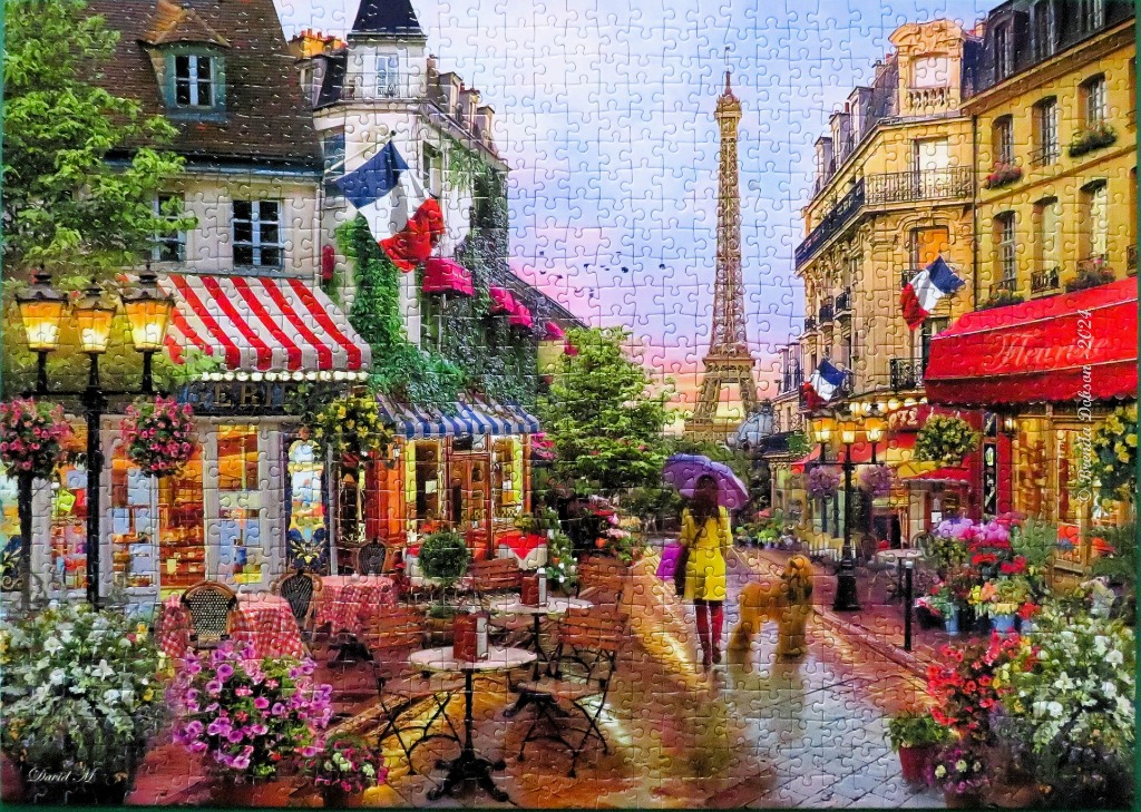 A scenic Parisian street view with a cafe, a woman walking a dog, and the Eiffel Tower in the distance.