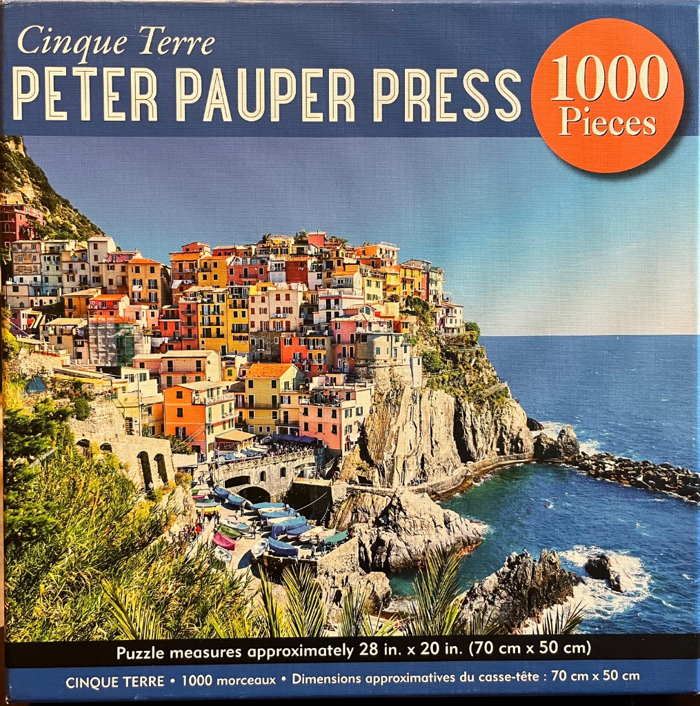 A scenic photograph of the colorful hillside village of Manarola in Cinque Terre, Italy, overlooking the sea.