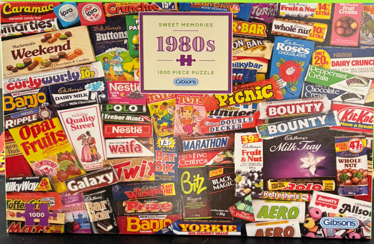 A collage of vintage 1980s candy and chocolate bar wrappers and packaging.