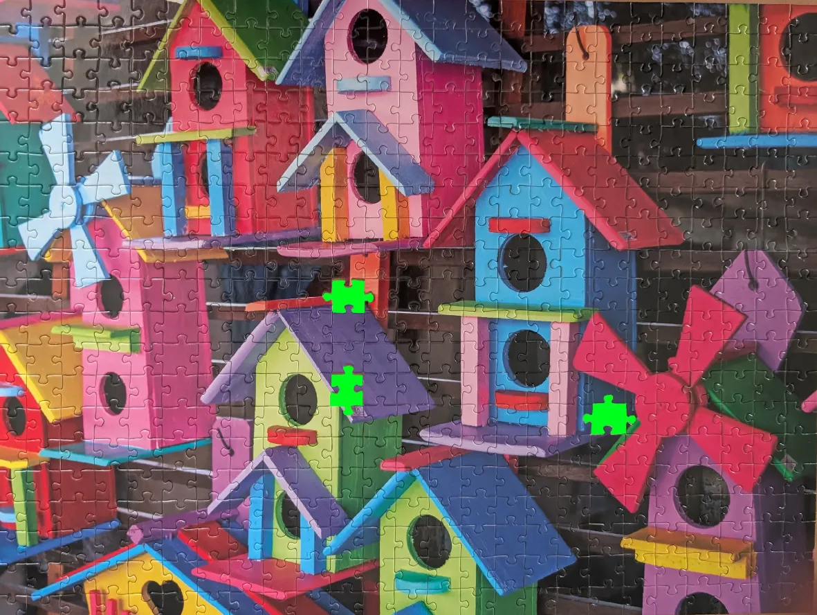 A collection of brightly painted, whimsical wooden birdhouses with windmills and vibrant colors.