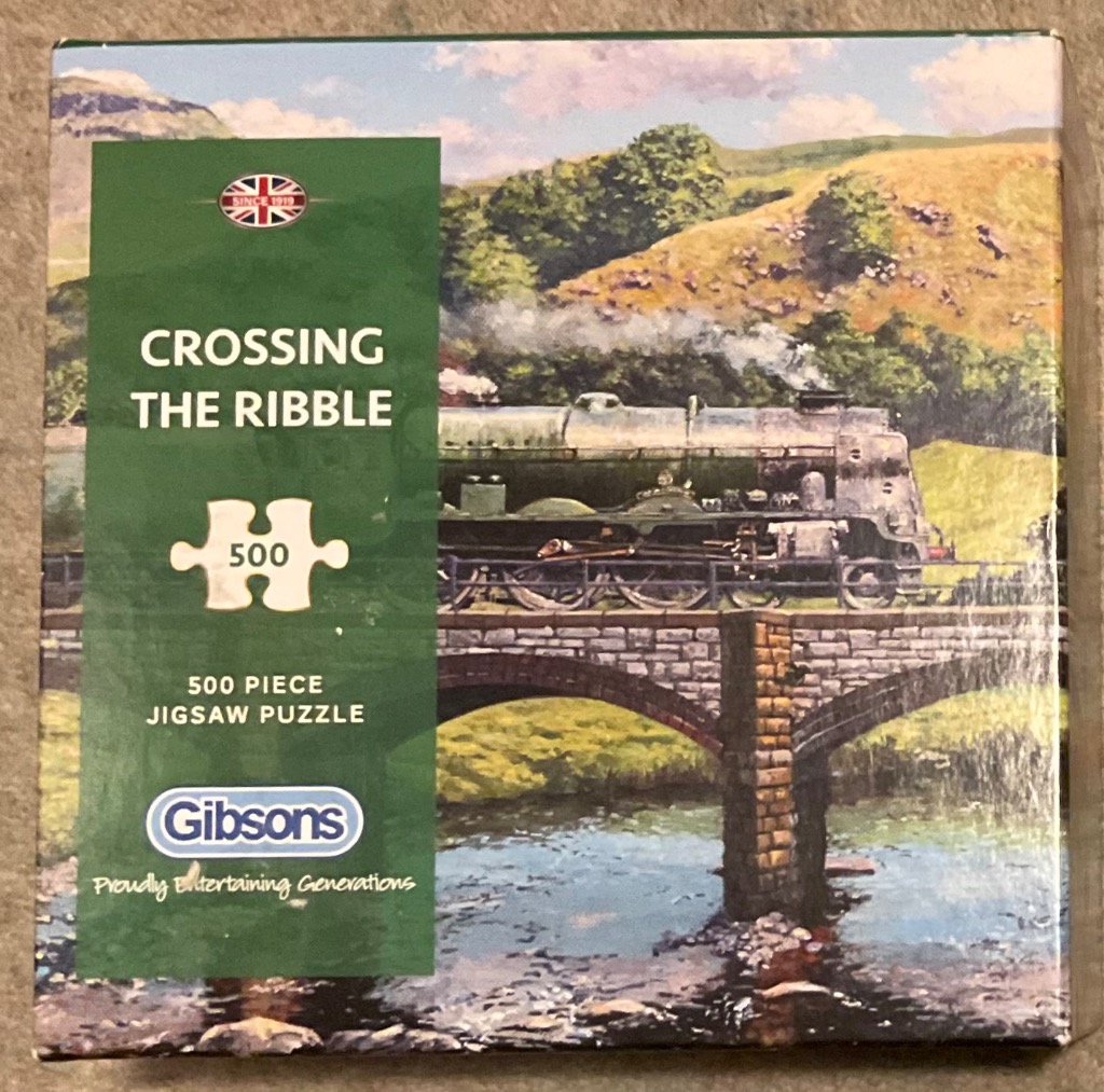 A steam train crossing a stone bridge over a river in a rural landscape.