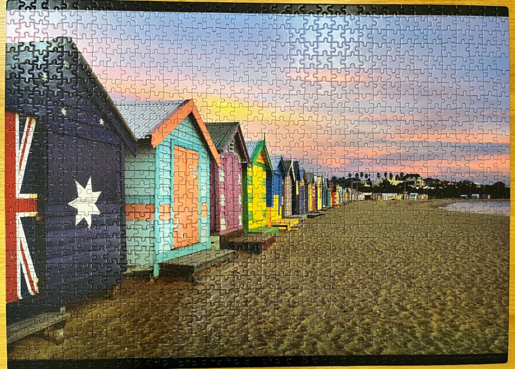 A row of colorful Brighton beach huts at sunset.