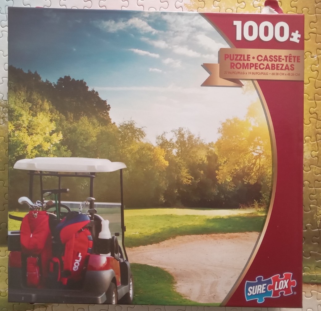 A golf cart parked on a sunny course with trees and a sand trap in the background.