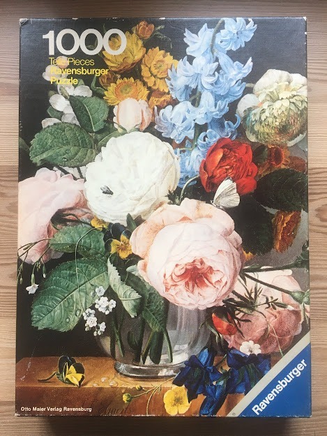 Classical Dutch-style still life painting featuring a vibrant, multi-colored bouquet of flowers in a glass vase.