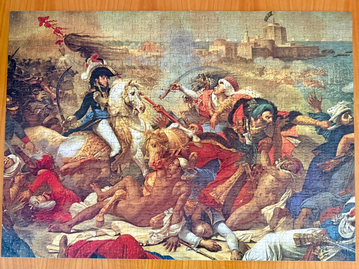 A dramatic 19th-century history painting depicting a chaotic battle scene with Napoleon Bonaparte on a white horse.