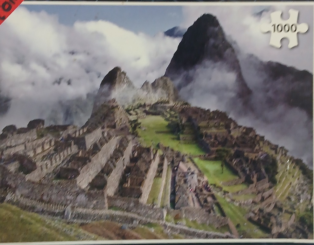 Machu Picchu ancient ruins nestled between mountain peaks in the mist.