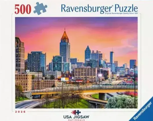 Atlanta skyline at sunset with illuminated highway overpasses in the foreground.