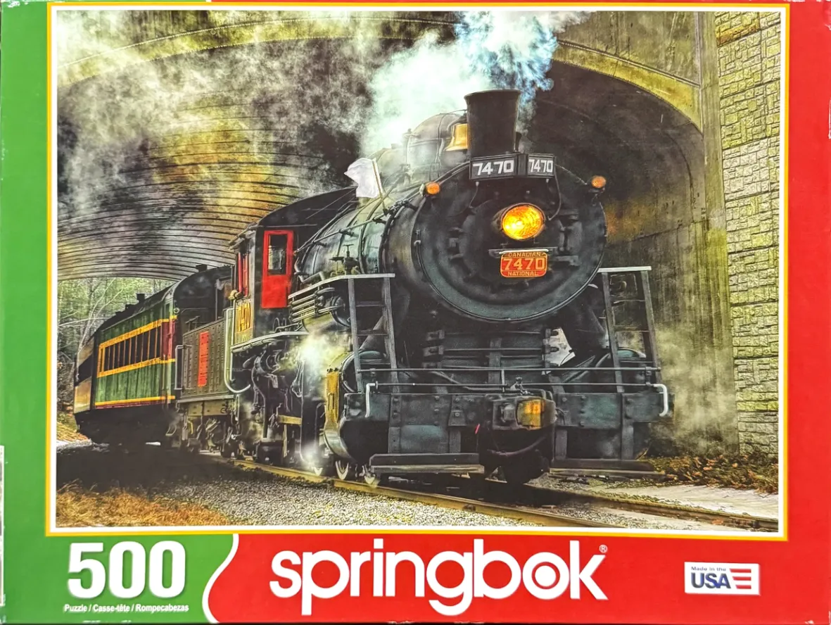 A vintage steam locomotive pulling a passenger car out of a stone tunnel, emitting plumes of white and black smoke.