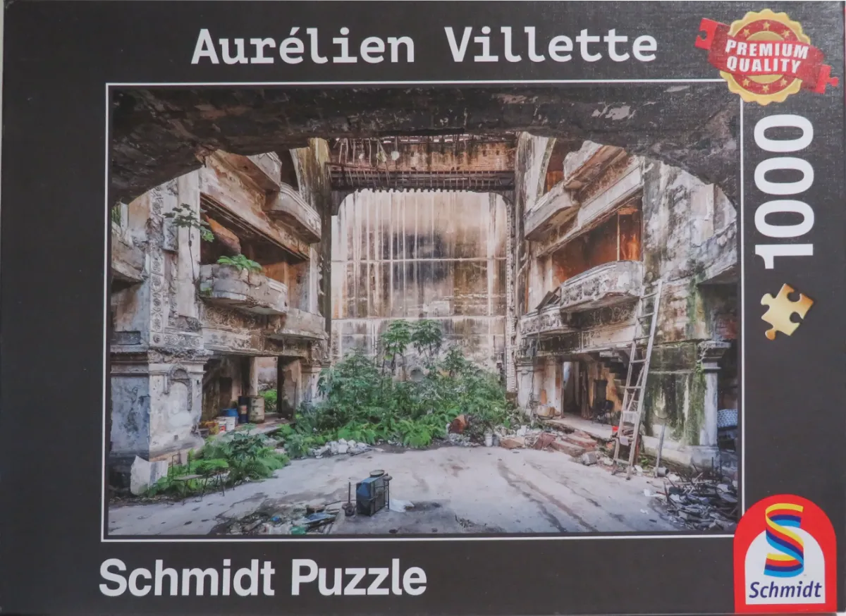 Interior of a ruined, derelict theatre overgrown with lush green vegetation.