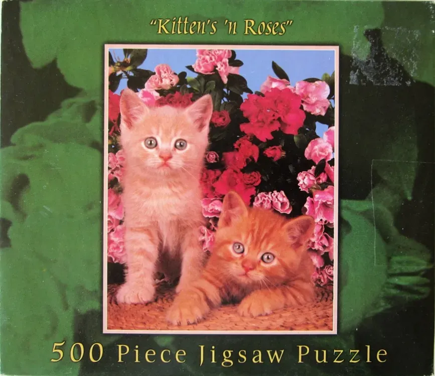 Two ginger kittens posing in front of a vibrant bush of pink and red azalea flowers.