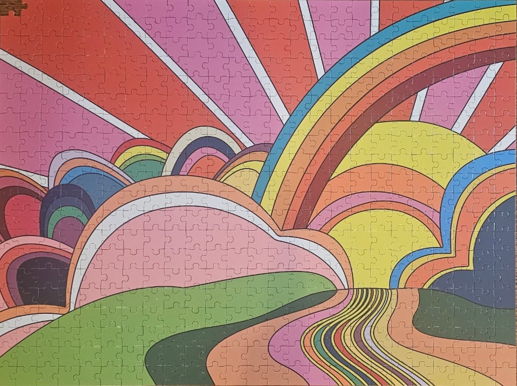 An abstract 1970s-style illustration of colorful layered hills and a sunburst pattern.