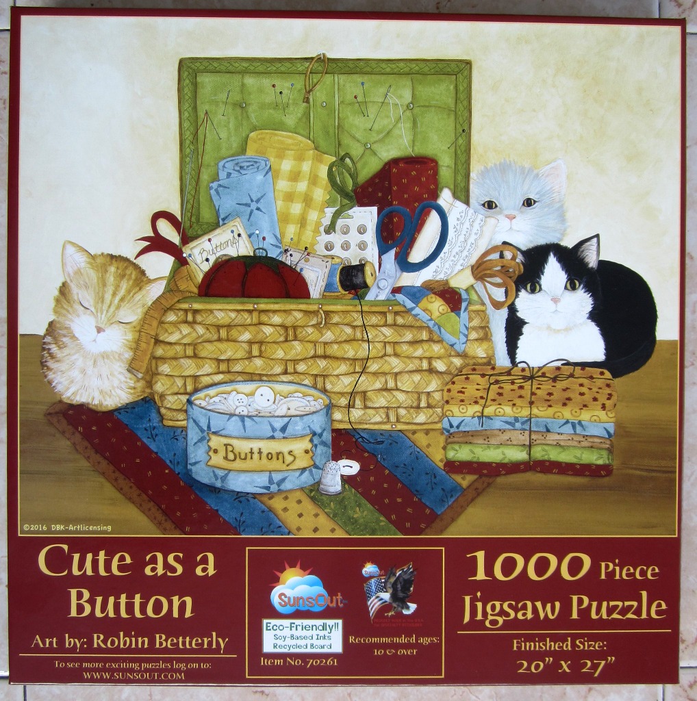 A painting of two cats sitting by a wicker basket filled with sewing supplies and a container of buttons.
