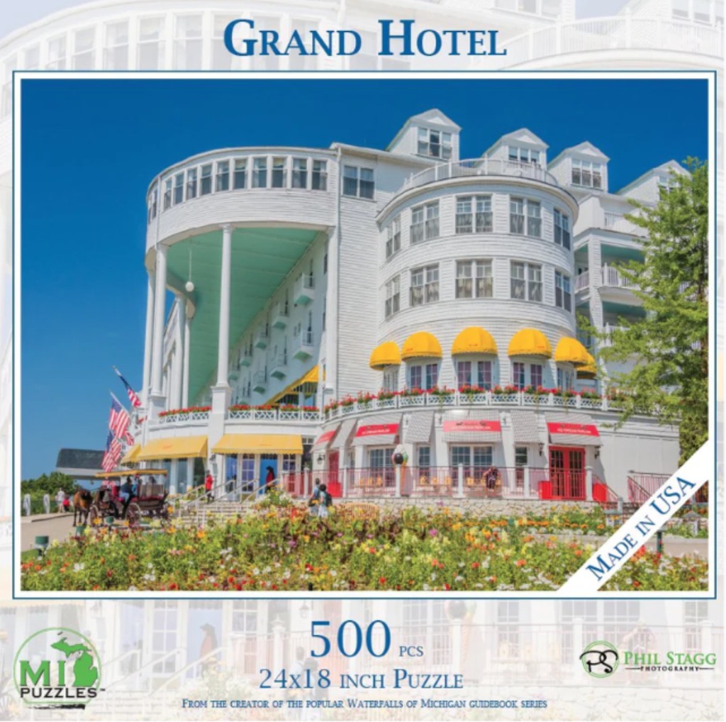 A sunny, low-angle photograph of the historic white Grand Hotel on Mackinac Island featuring a horse-drawn carriage.