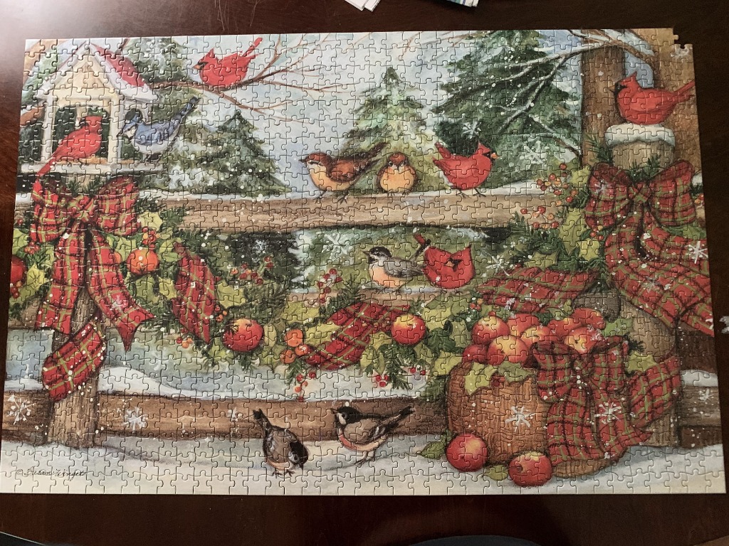 Winter scene featuring red cardinals, songbirds, a birdhouse, and plaid ribbon decorations on a wooden fence.