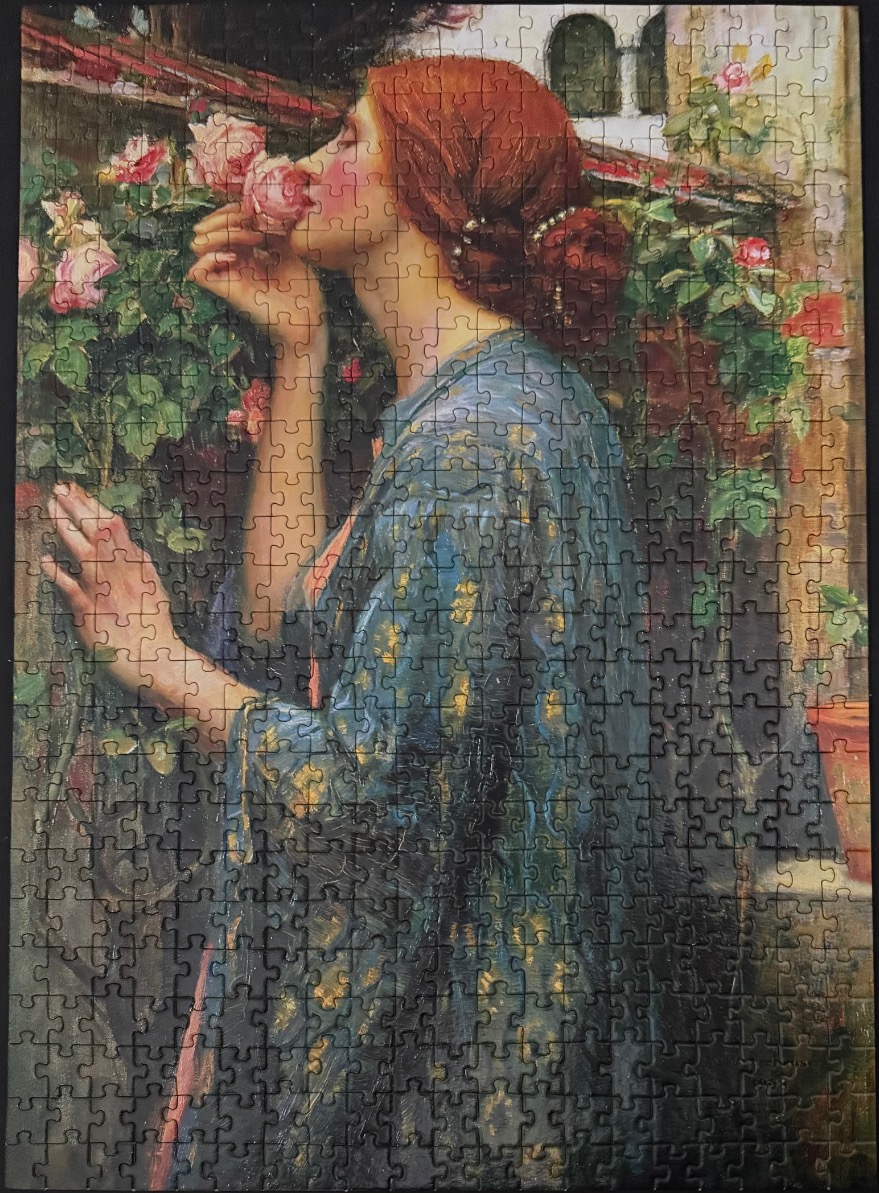 A Victorian-style painting of a red-haired woman in a blue robe smelling roses in a garden.