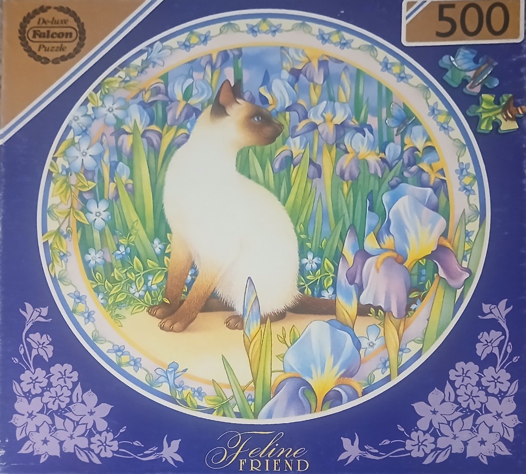 A Siamese cat sitting in a garden of blue and purple irises inside a circular frame.