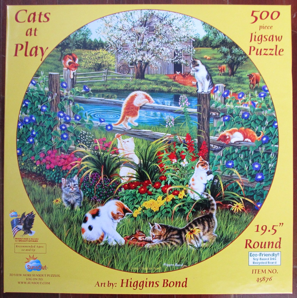 A countryside scene featuring multiple kittens playing in a garden near a pond, a wooden fence, and a blooming fruit tree.