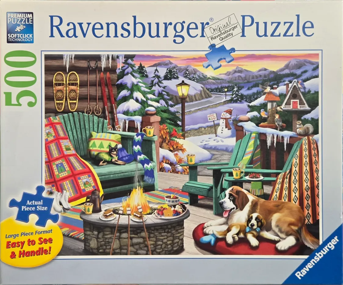 A cozy winter patio scene with a fire pit, several dogs, and snow-covered mountains in the background.