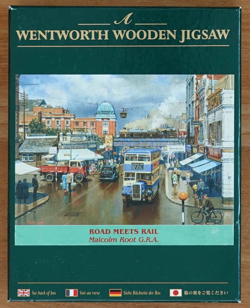 Painting of a 1950s British street scene with a steam train crossing a bridge above a double-decker bus.