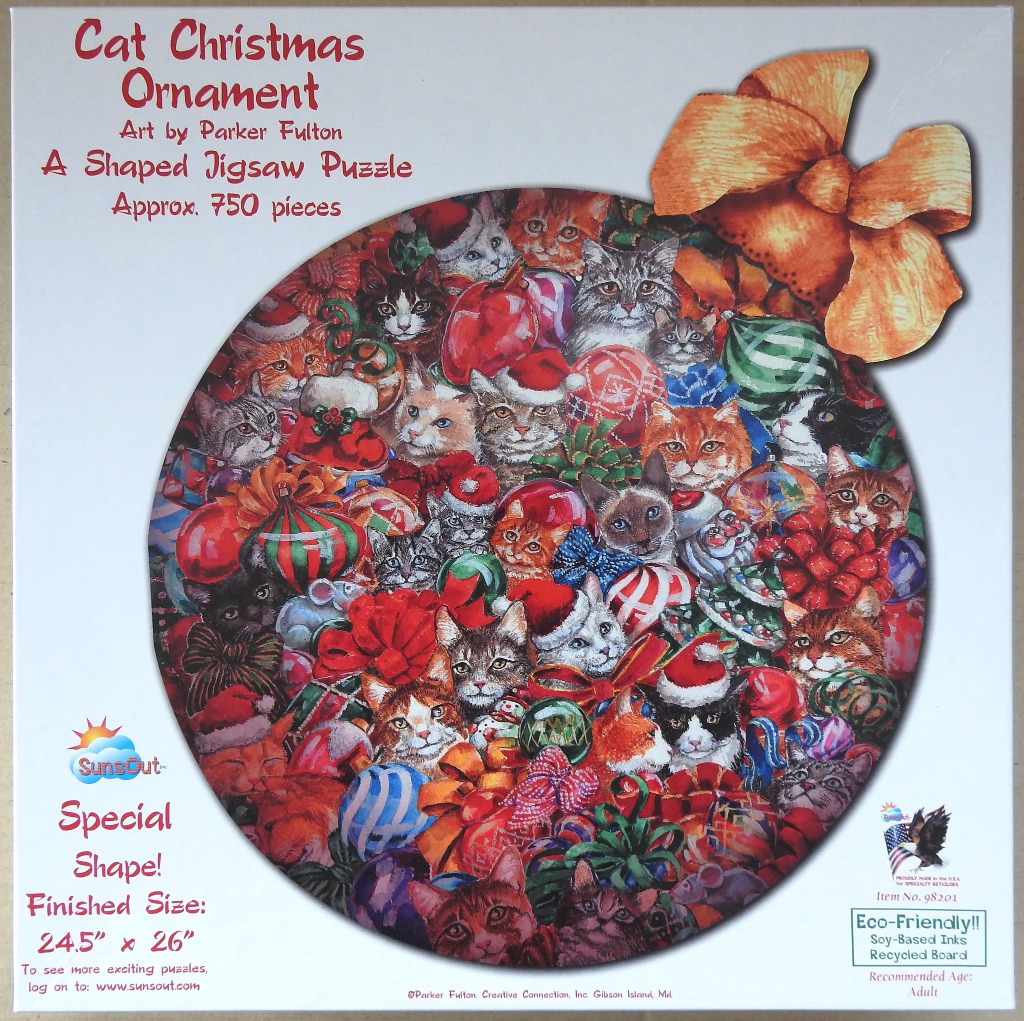 A holiday illustration of many cats nestled among Christmas ornaments, shaped like a large round bauble with a gold bow.